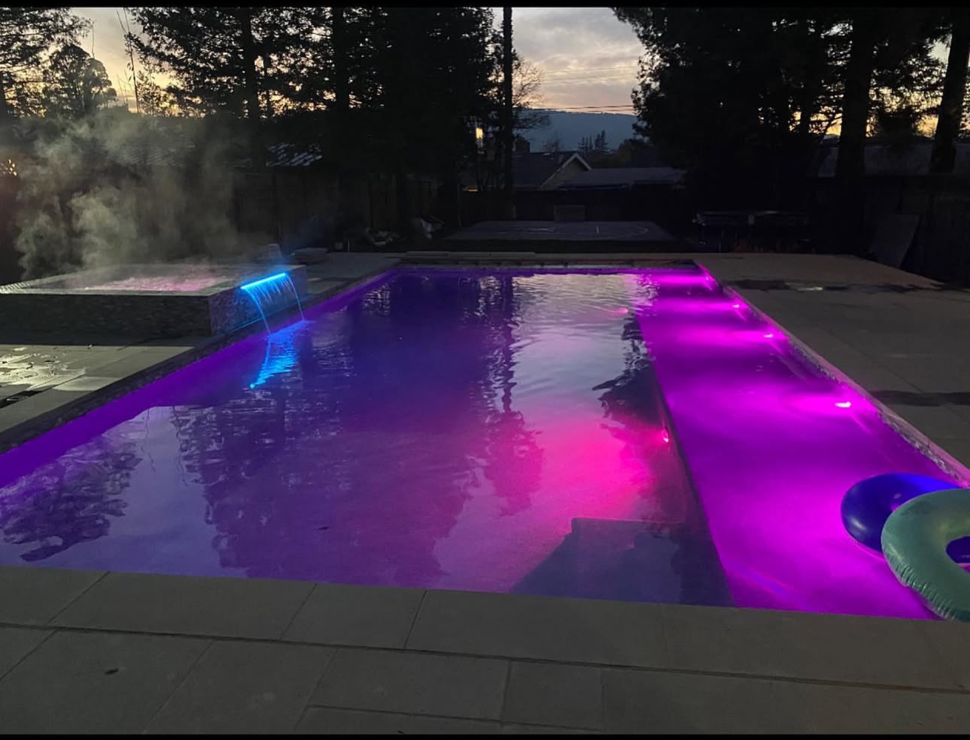 Luxury pool with vibrant LED lighting at dusk